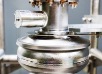 A closeup view of a the silver colored LCLS-II SRF cavity