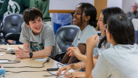 Group of students laughing and interacting around a table during the Virginia Regional Science Bowl.