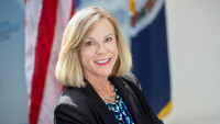 Jefferson Lab Director Kimberly Sawyer with American and Virginia flags in background